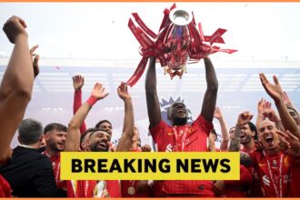 Ibrahima Konate lifts the Premier League trophy with Liverpool