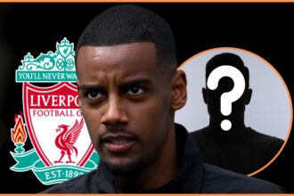 Alexander Isak looks on in front of Liverpool club crest.