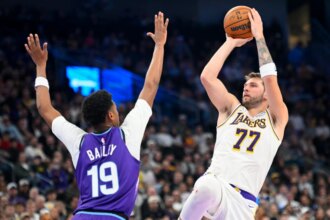 Los Angeles Lakers' No. 77 Luka Doncic shoots Utah Jazz's Ace Bailey No. 19 during the second half of a game at Delta Center on November 23, 2025 in Salt Lake City, Utah.