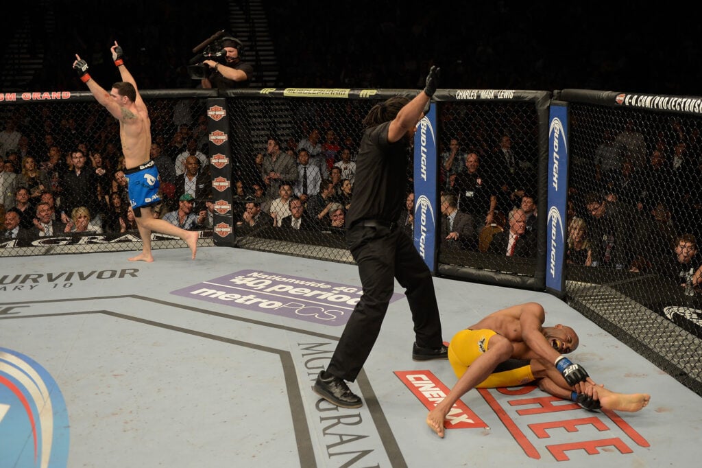 Chris Weidman celebrates as Anderson Silva holds his leg in pain at UFC 168