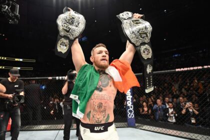 Conor McGregor celebrates winning both belts at UFC 205