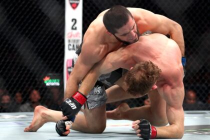 Islam Makhachev takes the back of Jacques Della Maddalena during their UFC 322 match