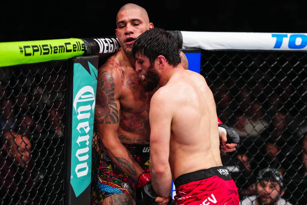 Magomed Ankalaev controls Alex Pereira against the cage in their title fight at UFC 313.