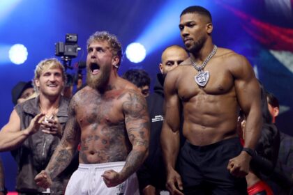 Anthony Joshua looks on unimpressed as Jake Paul bends over and screams while Logan Paul claps in the background