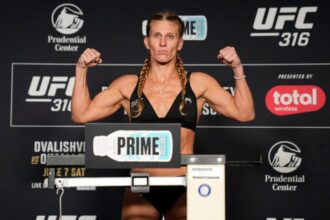 Kayla Harrison poses on the scale at the official weigh-in for UFC 316