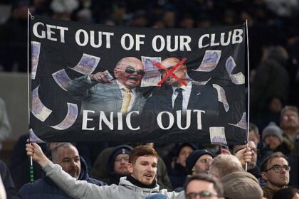 Tottenham fan holds up a banner protesting against the club