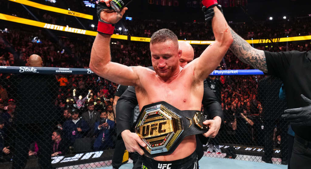 Justin Gaethje raises his hands and wraps them around his UFC title at UFC 324