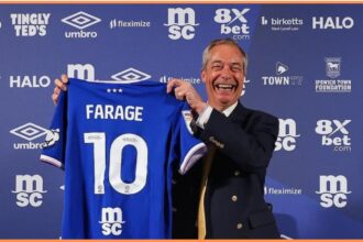 Nigel Farage posting with an Ipswich Town shirt