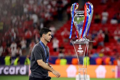 Mikel Arteta walks past the Champions League trophy after PSG defeat
