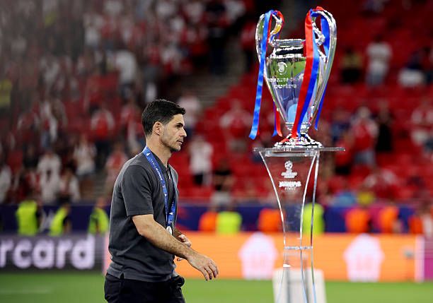 Mikel Arteta walks past the Champions League trophy after PSG defeat